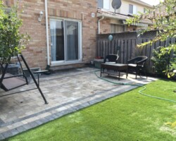 Small yard with artificial turf and patio