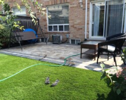 Small yard with artificial turf and patio