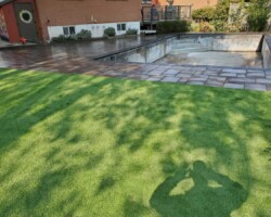 Artificial turf on yard between garden and pool